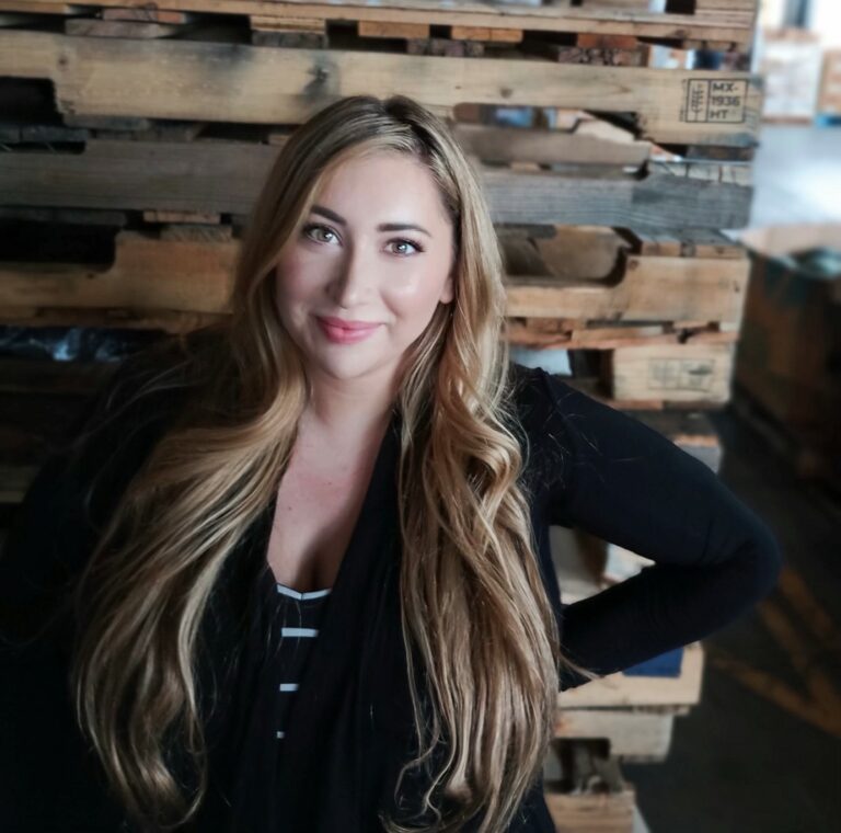 Stevie in front of a stack of pallets