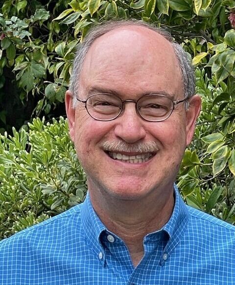Jim smiling in front of foliage