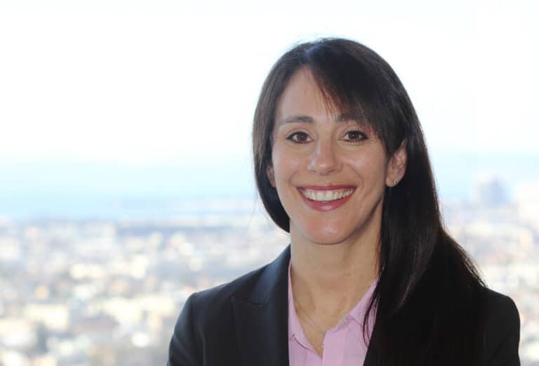 Pam smiling in front of a city backdrop